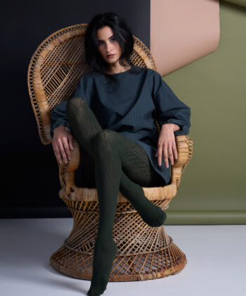 Woman seated in a wicker chair.